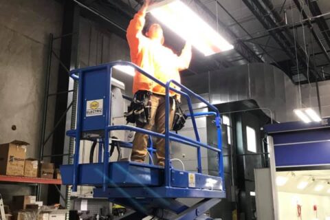 man fitting lights in warehouse