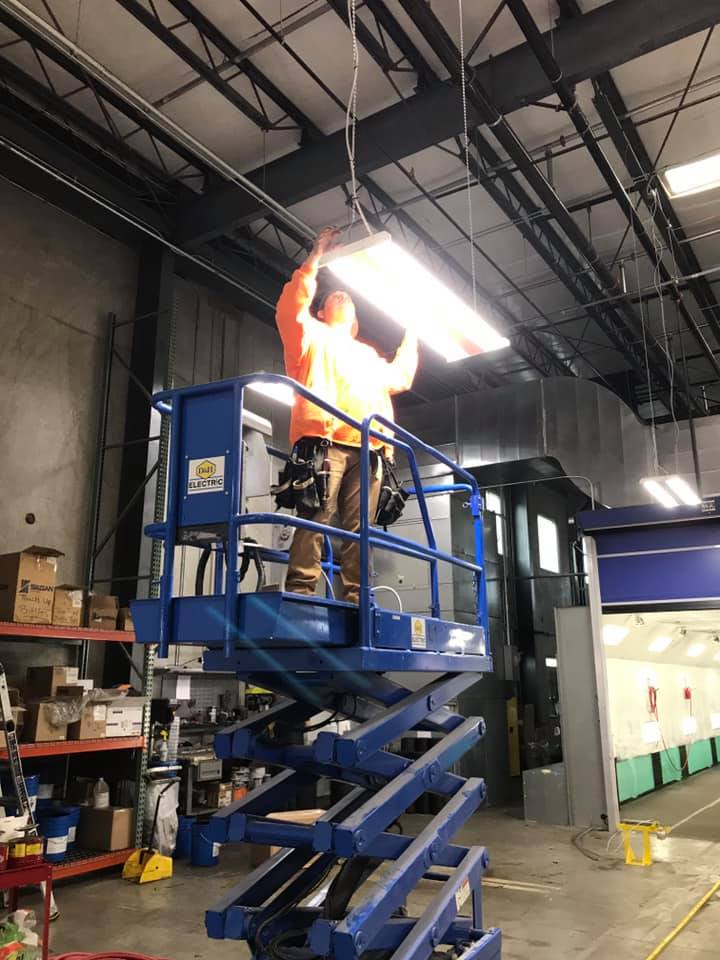 man fitting lights in warehouse